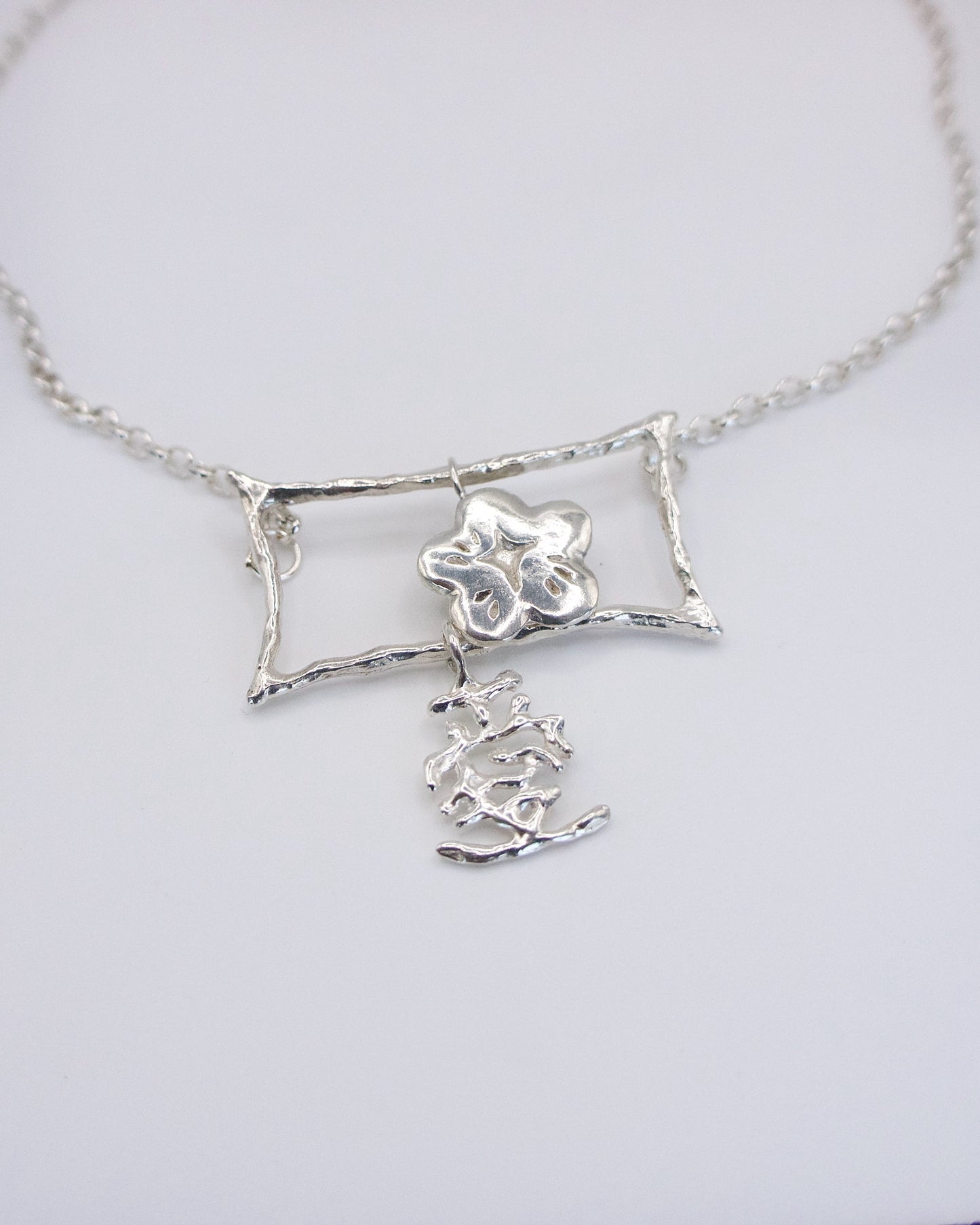 close up on brushstroke detail movable silver pendant, love in Chinese