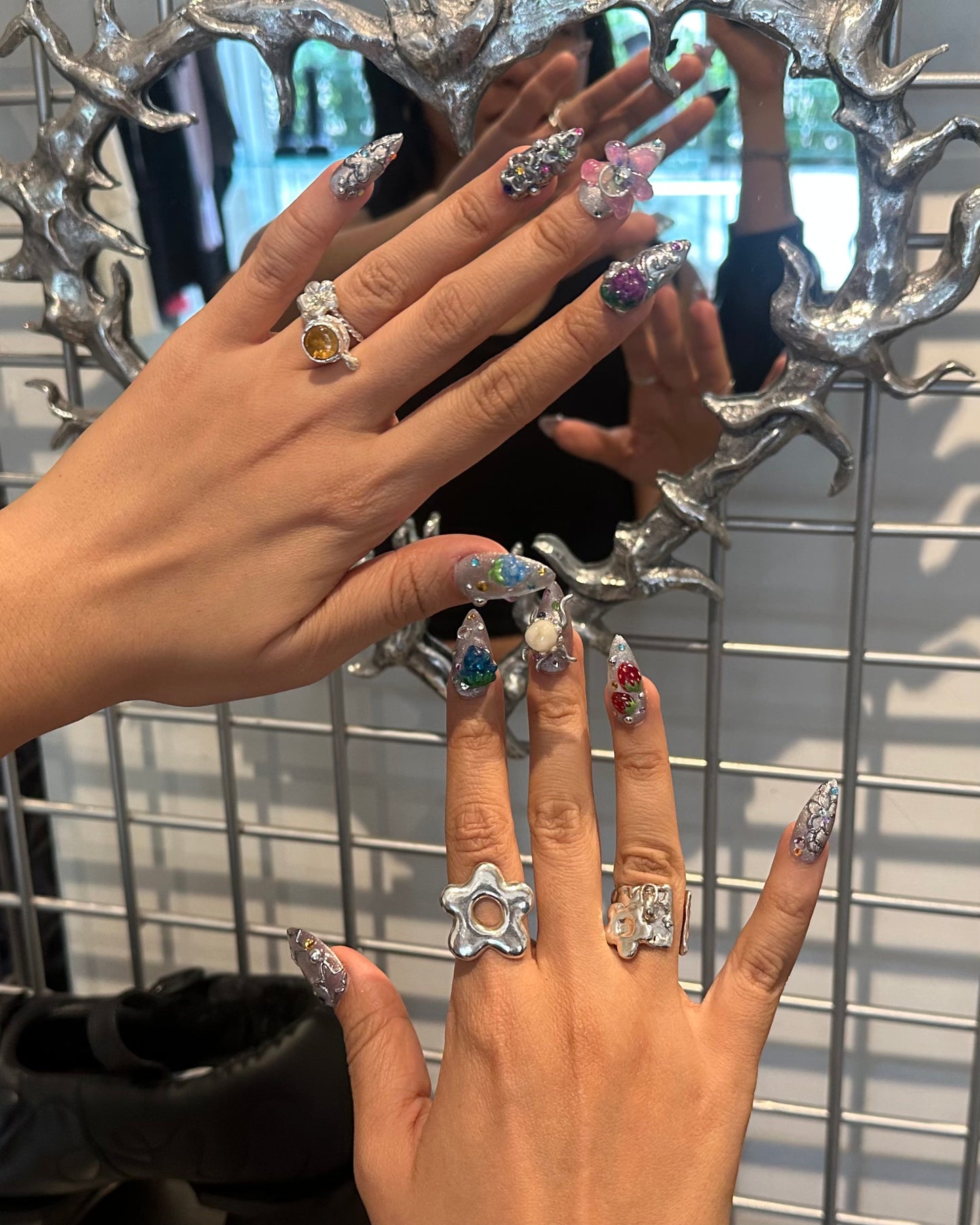 person wearing various 935 silver rings made in mexico city, flowers
