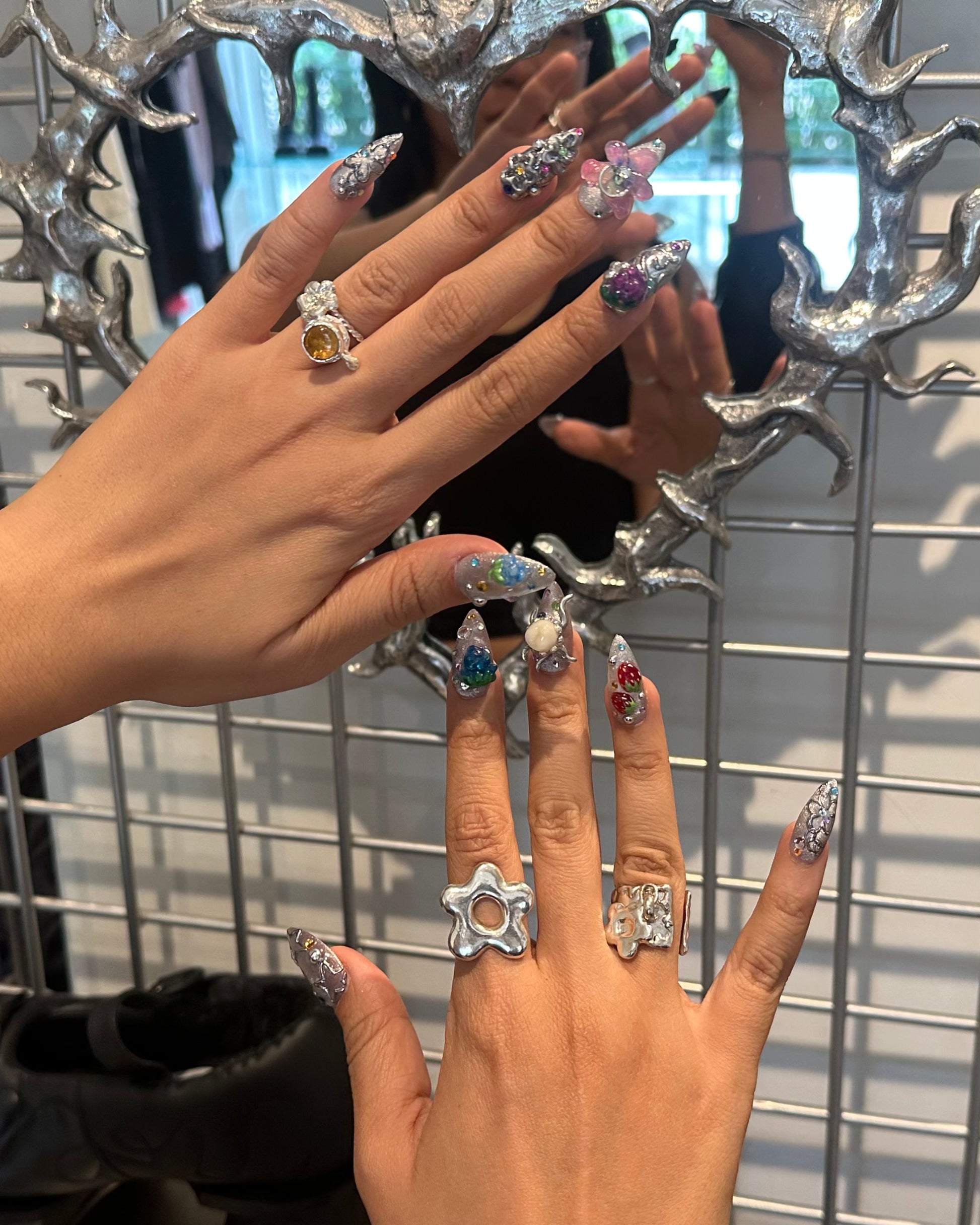 person wearing various 935 silver rings made in mexico city, flowers